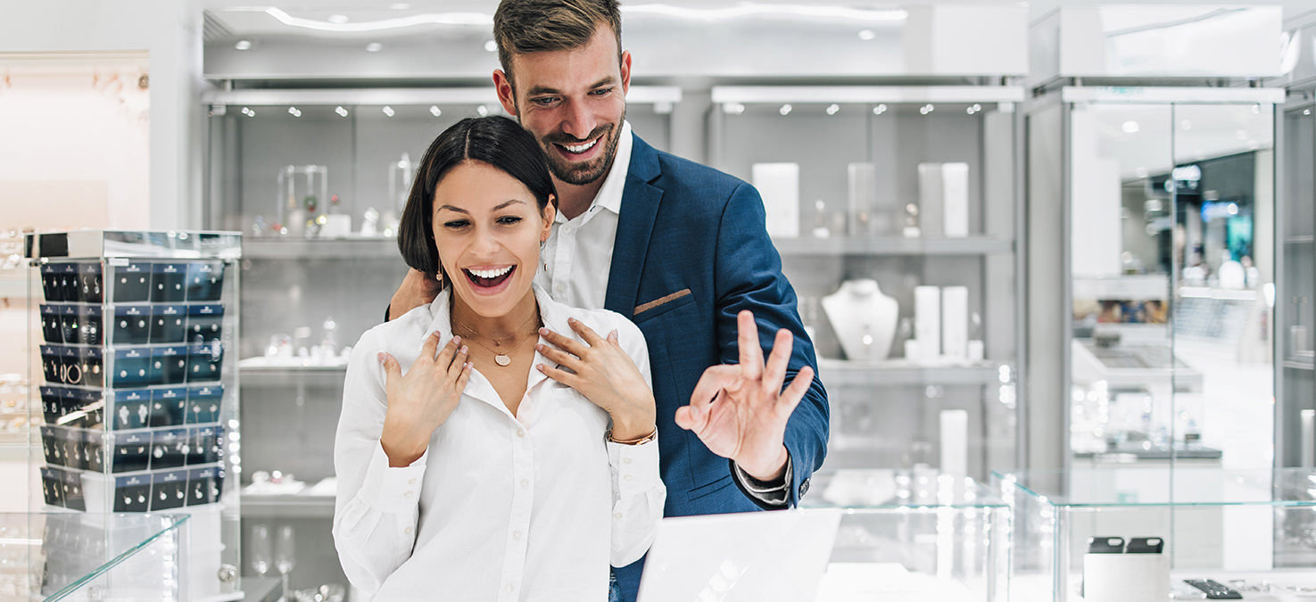 Fröhlicher Mann im Warenlager, vor Kartons stehend.