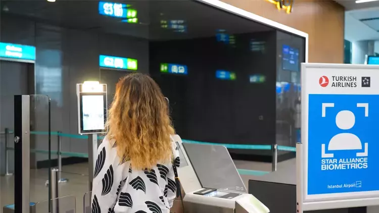 Woman with hand luggage in airport shopping mall.